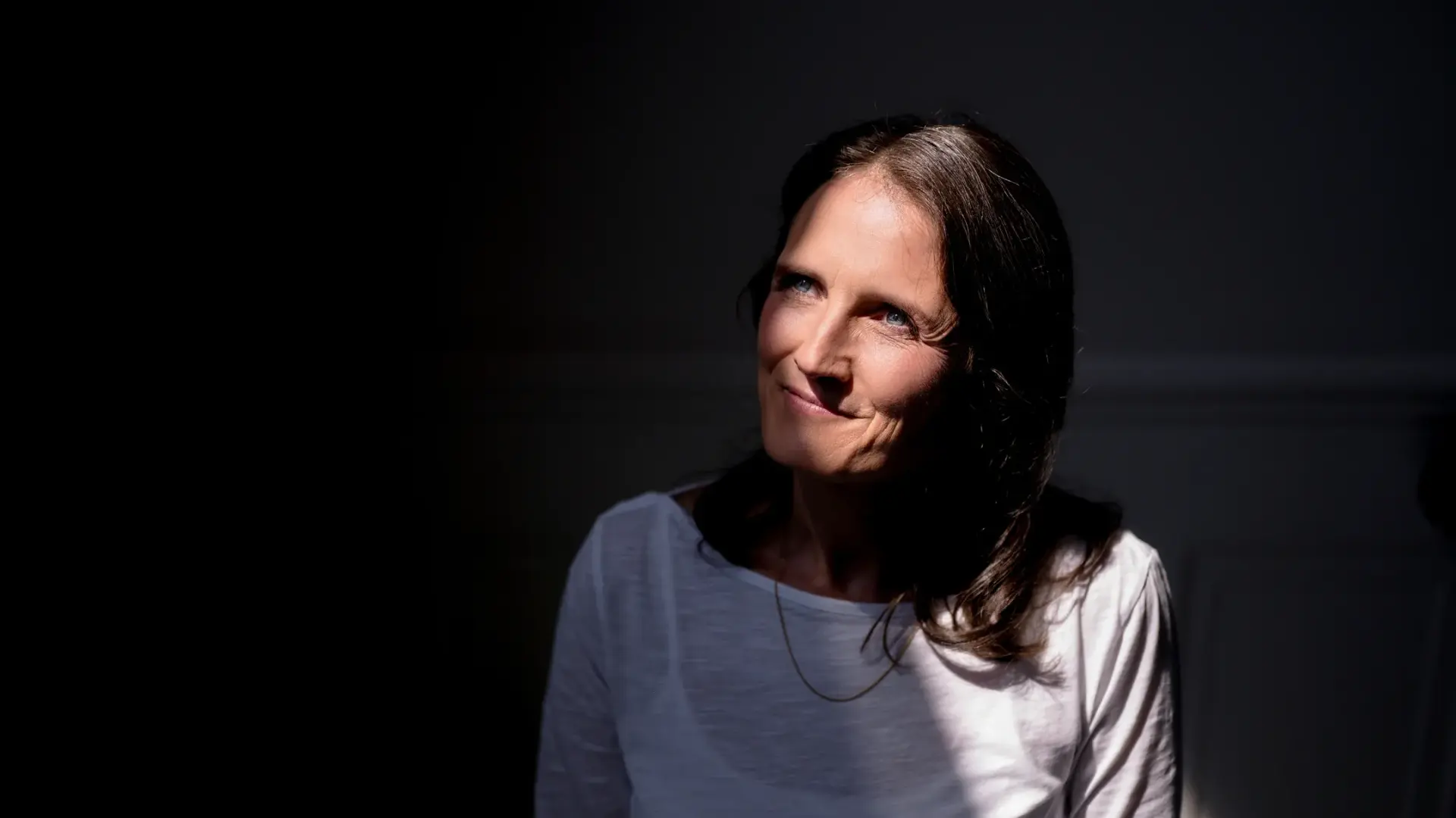 Eva Will steht vor einer Wand im Licht – Heilpraktikerin in Bremen.
